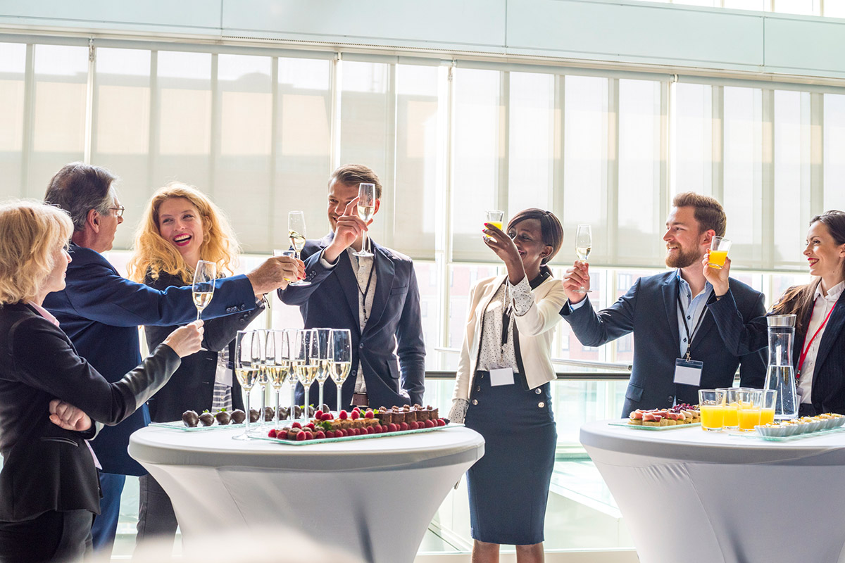 Colleagues on business event standing and toasting with champagne